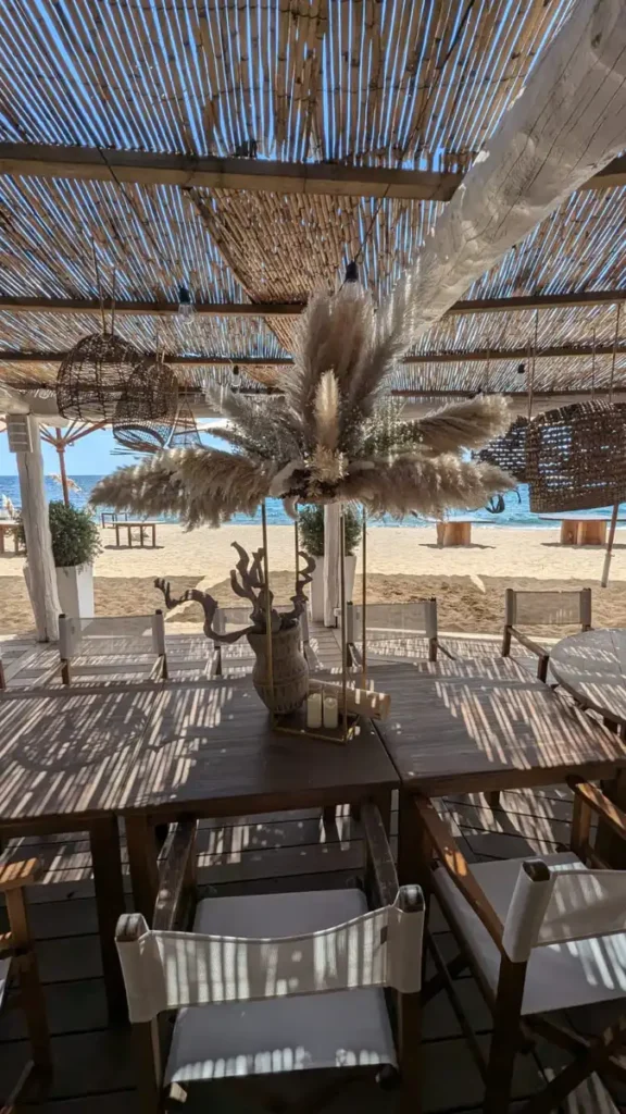 Centre de table en pampa entièrement réalisé par iliade location pour un mariage sur la plage du 44 à saint maxime sur iune belle table en bois