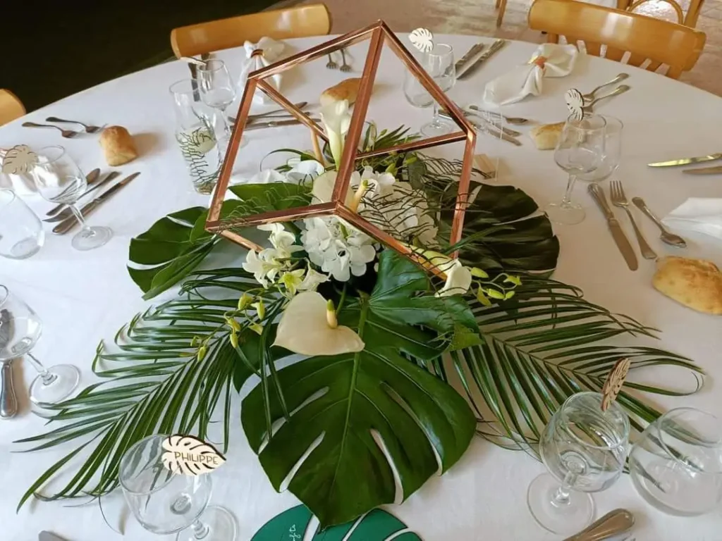 centre de table florale, avec colonnes dorées de forme carré et composition florale.