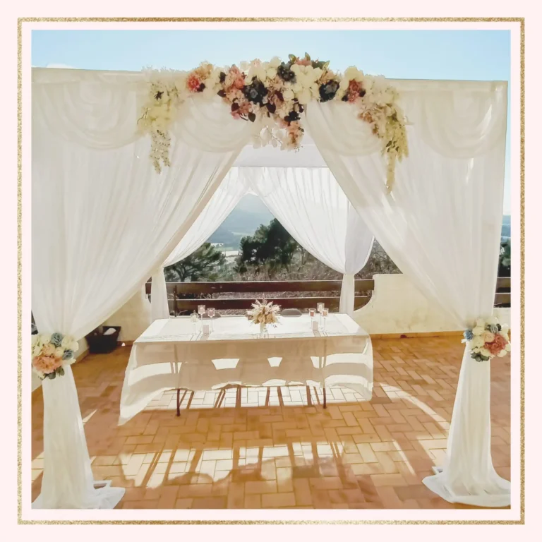 Location de houppa de mariage dans le Var, ornée de fleurs fraîches et de voilages blancs, avec une vue imprenable sur la mer.