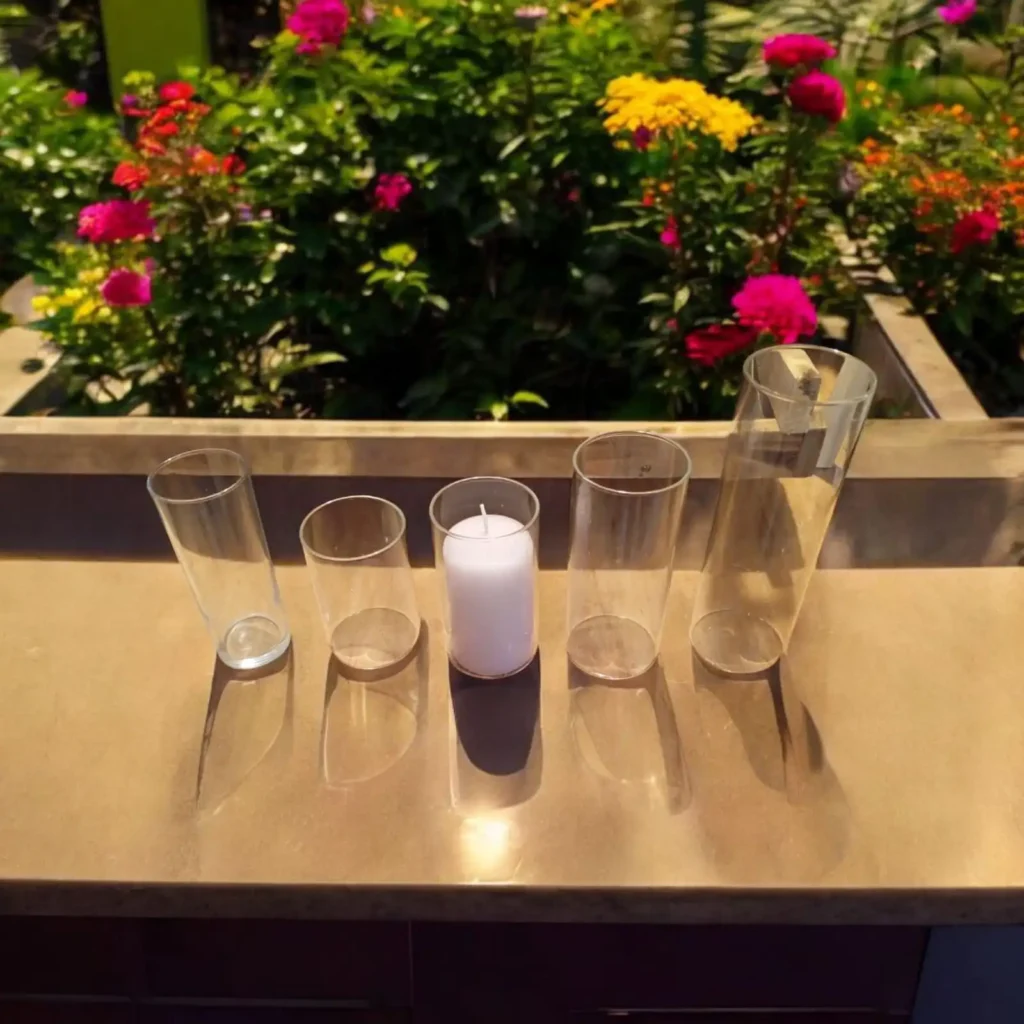 Photophores en verre transparents avec bougie blanche pour décoration de mariage en extérieur.