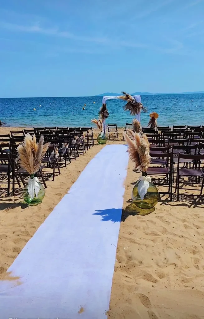 Cérémonie laïque sur la plage de La Londe-les-Maures, arche décorée de pampas et chaises disposées face à la mer.