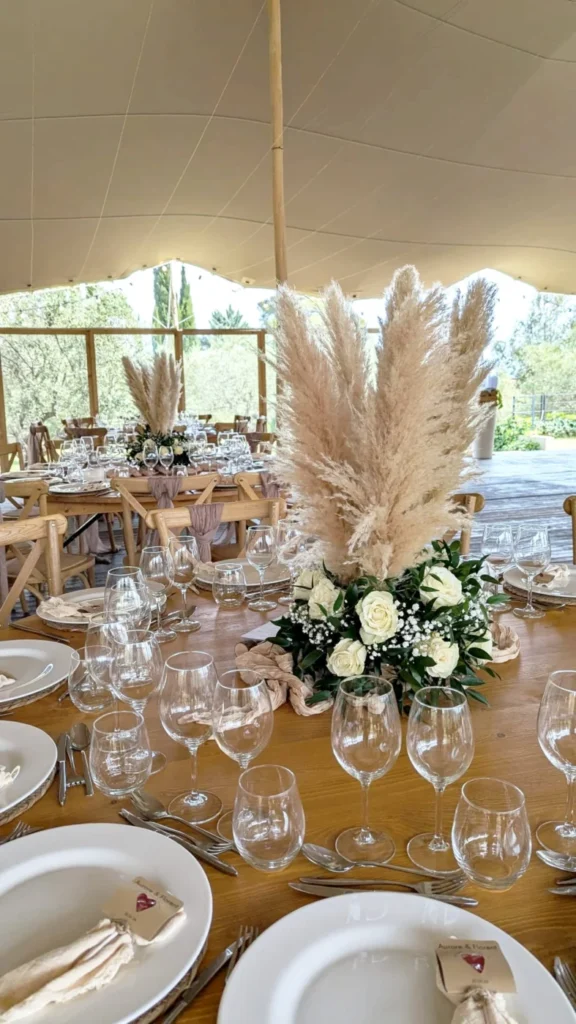 Centre de table mariage avec pampas, roses blanches et feuillage vert