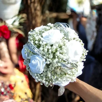 Bouquet de mariée rond et moderne, composé de roses blanches et de gypsophile, avec structure argentée originale.