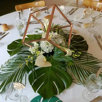 centre de table florale, avec colonnes dorées de forme carré et composition florale.